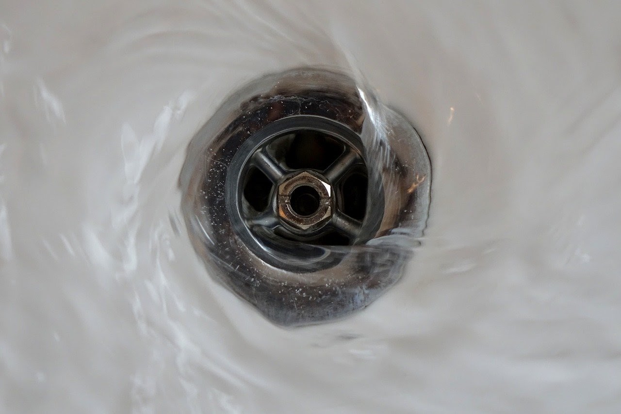 Water washing down a drain.