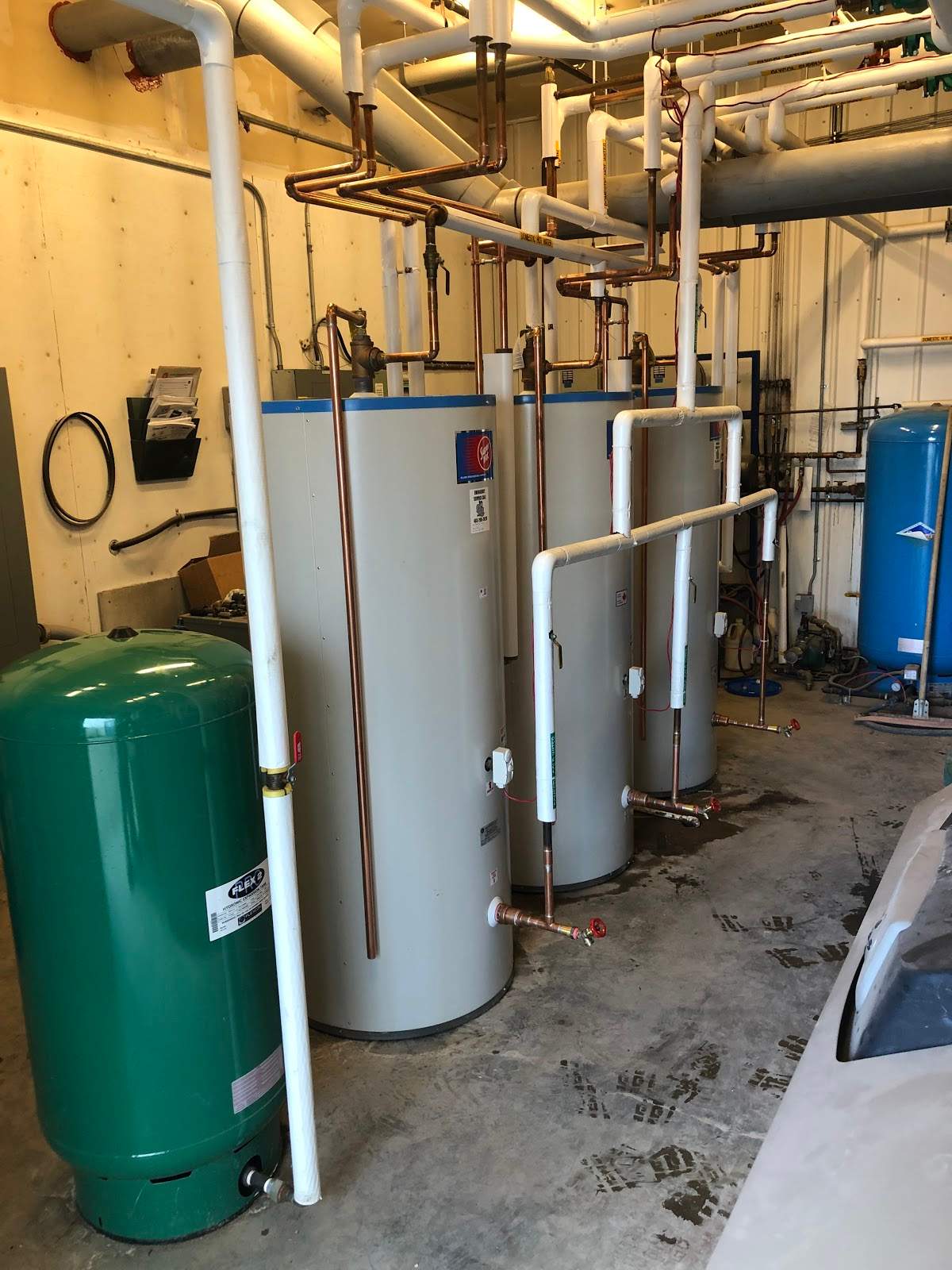 three hot water tanks installed in an interior space.