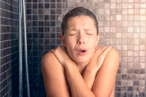 A person wincing under a cold shower.